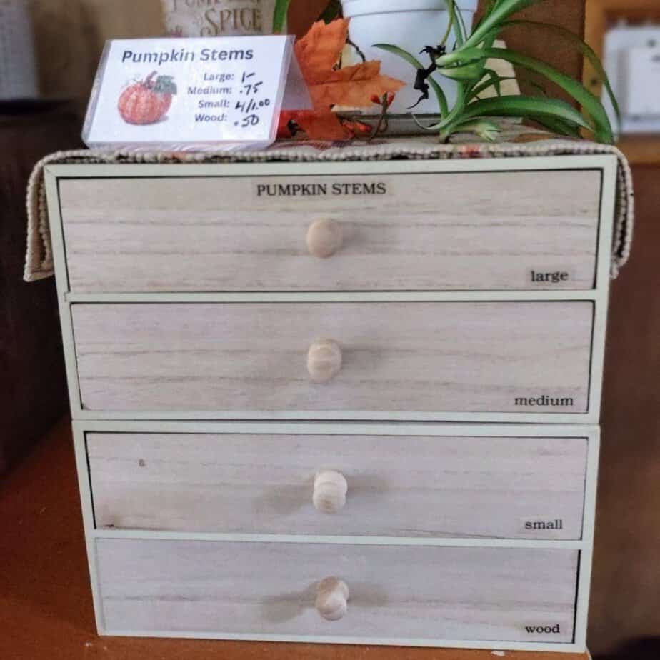 smll chest of drawers with various sizes of dried pumpkin stems
