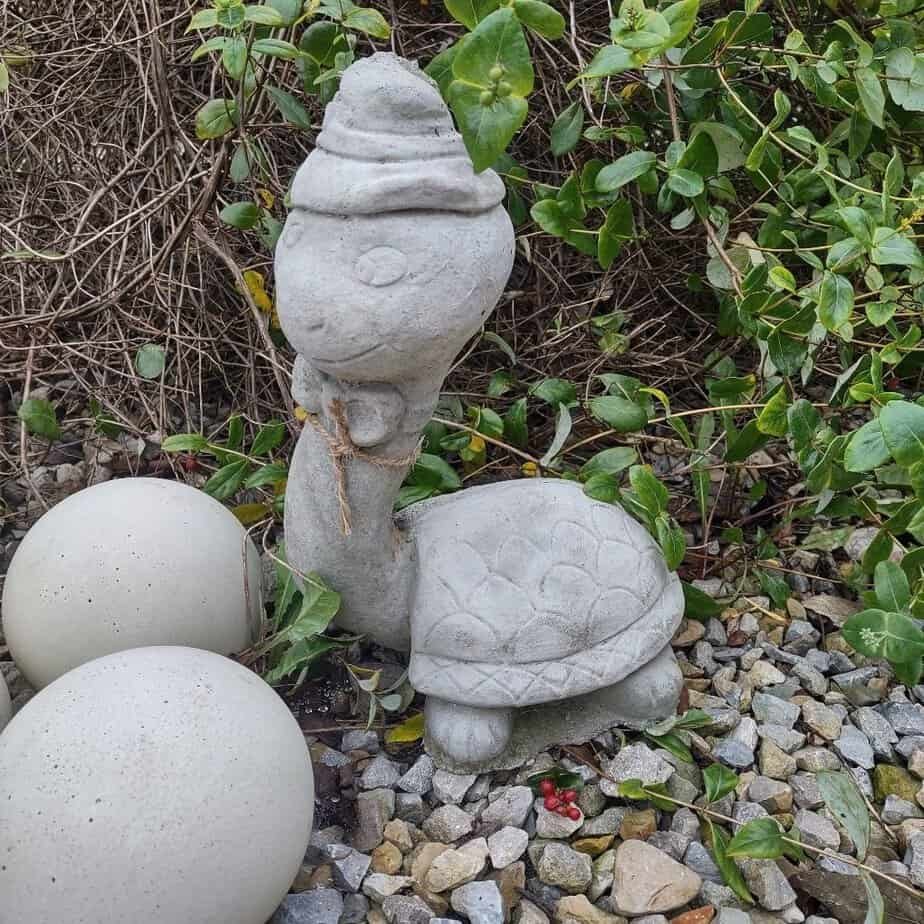 concrete turltle with a long neck and hat